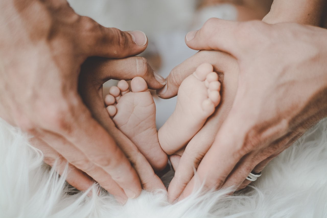 Tabloul inspirational Picioare bebe in mainile parintilor